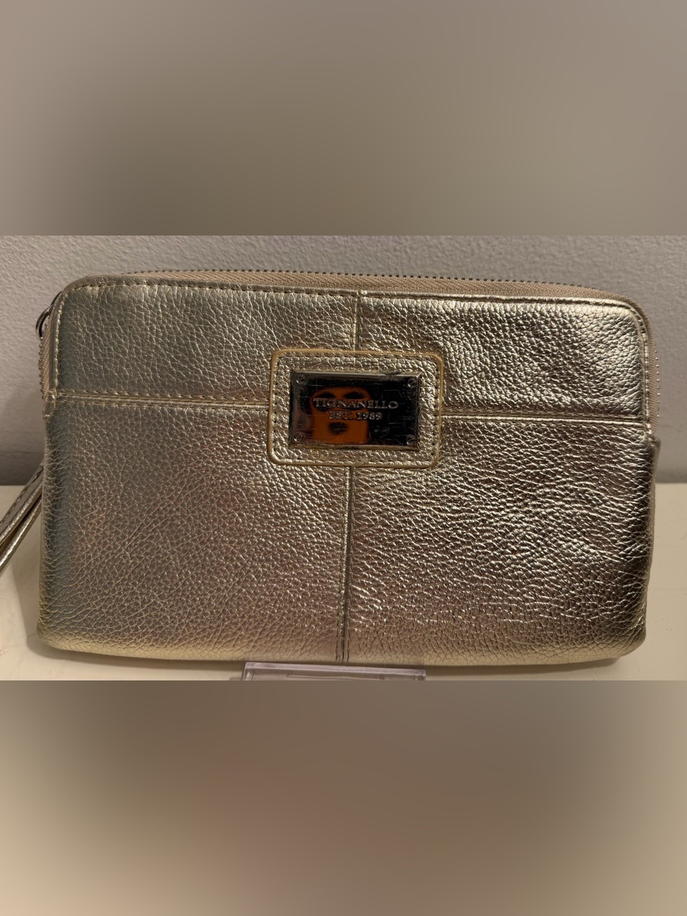 Tignanello metallic gold leather wristlet/wallet is in good preowned condition.
